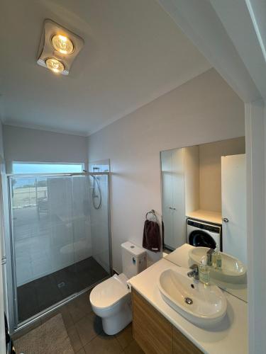 a bathroom with a toilet and a sink and a shower at Pelican Lagoon Retreat in Pelican Lagoon
