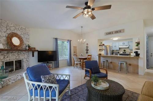 a living room with blue chairs and a fireplace at Cypress Retreat Cozy Ft Myers Pet Friendly Home in Fort Myers