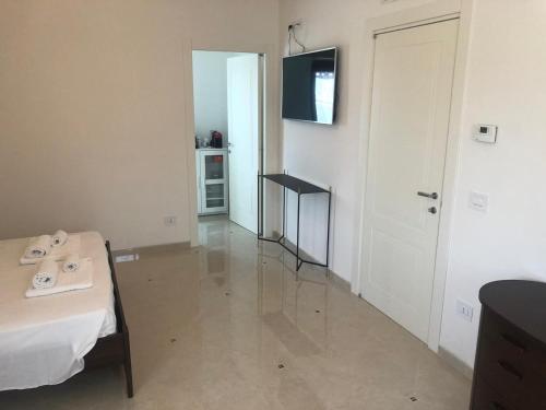 Villa Carmen Resort في كامبوباسو: غرفة بها سرير وتلفزيون على الحائط