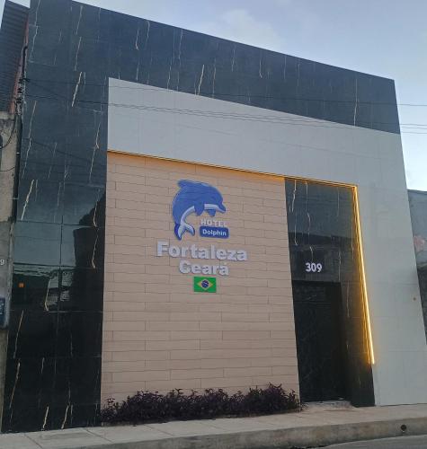 a building with a sign on the side of it at Hotel Dolphin Fortaleza in Fortaleza