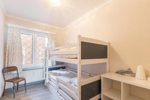 een slaapkamer met een stapelbed, een bureau en een bureau bij Sun Beach 0201 in Sint-Idesbald