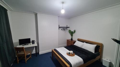 a bedroom with a bed and a desk with a computer at Supported Guest rooms near Fratton Park in Portsmouth