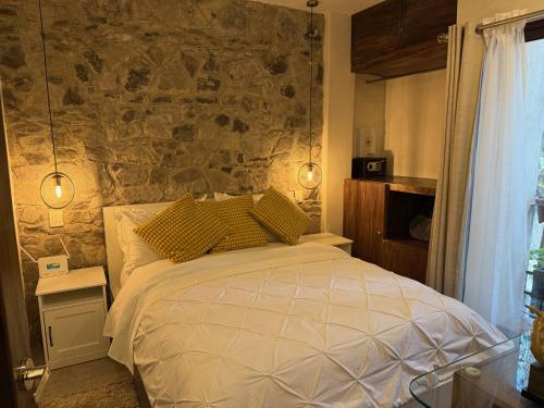 a bedroom with a bed and a stone wall at Firenze en ValQuirico in Santeagueda