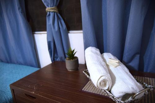 a table with towels and a plant on a bed at Suites Maderos San Benito in San Salvador