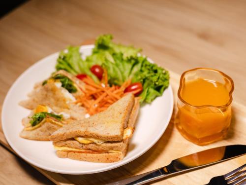 einen Teller Essen mit einem Sandwich und einem Salat in der Unterkunft The City Yaowarat in Samphanthawong