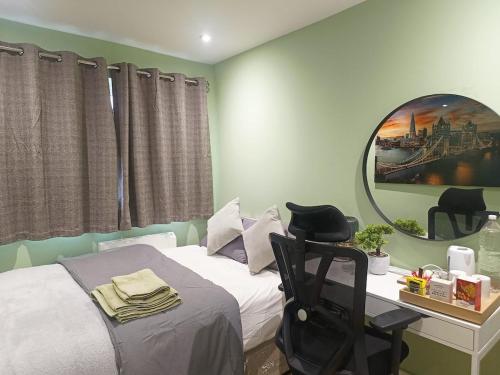 a bedroom with a bed with a desk and a mirror at Cosy Private Room in Greater London Easy Access to City & Excel in London