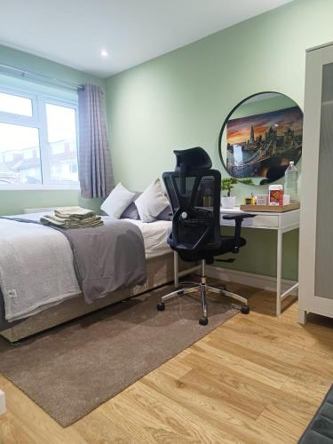 a bedroom with a bed and a desk and a chair at Cosy Private Room in Greater London Easy Access to City & Excel in London