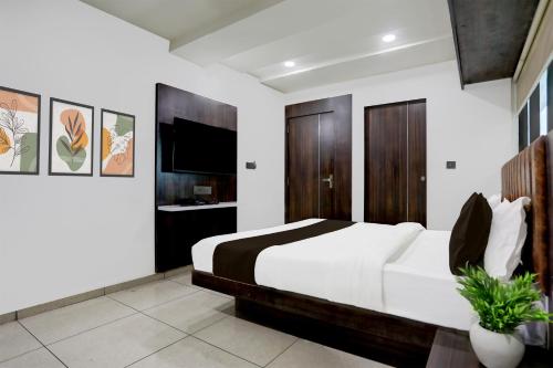 a bedroom with a large bed and a tv at Super Hotel O Nana Chiloda Near Airport Formerly Green Valley in Ahmedabad