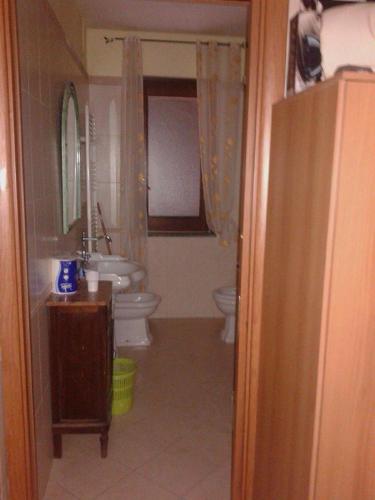 a bathroom with a sink and a toilet and a mirror at Green House in Nola
