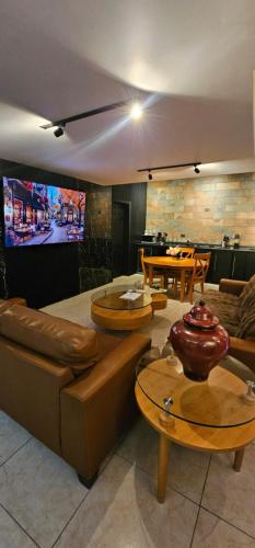 a living room with couches and tables and a tv at Luxury Suites Dubai a 100 mts del consulado in Ciudad Juárez