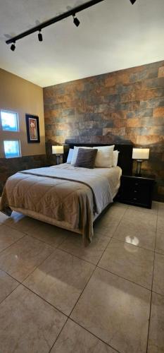 a bedroom with a bed and a brick wall at Luxury Suites Dubai a 100 mts del consulado in Ciudad Juárez