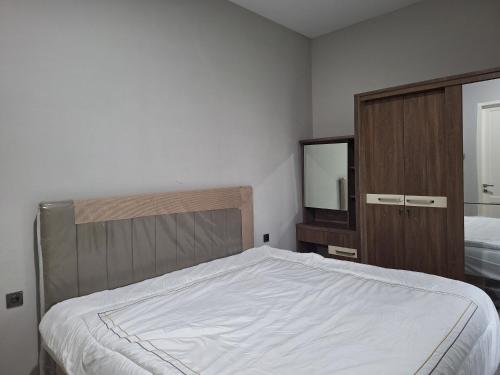 a bedroom with a bed and a dresser and a mirror at Rumah Cluster Springwood1 in Pontianak