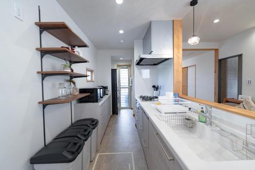 a kitchen with white counters and white cabinets at Guel Palacio in Miyako-jima