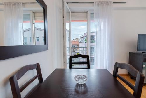 ein Esszimmer mit Tisch und Stühlen und einem Fenster in der Unterkunft Alex Cosy Quarters in Ohrid