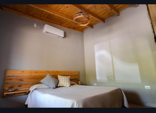 a bedroom with a bed with a wooden headboard at Tranqueras al Norte in Chascomús