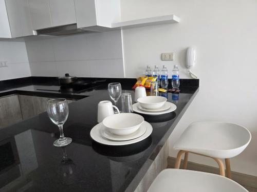 a kitchen with a counter with plates and wine glasses at Barranco Stay in Lima