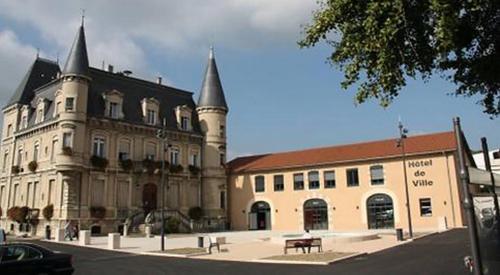 a large building with a bench in front of it at Appart Hôtel Bourgoin in Bourgoin