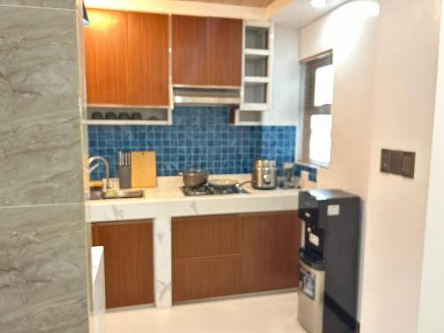 a kitchen with wooden cabinets and a black refrigerator at Cozy Baguio House Near Camp John Hay in Baguio