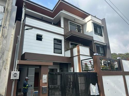 a man standing in front of a house at Cozy Baguio House Near Camp John Hay in Baguio