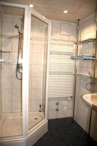 a bathroom with a shower and a tub and a sink at Landhaus Suntheim in Wertach
