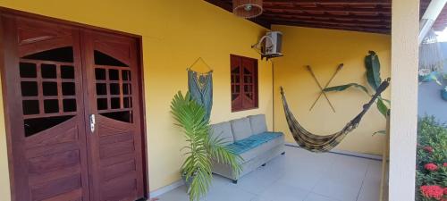 un porche con una hamaca en una casa en Chalé Aconchego dos Milagres, en São Miguel dos Milagres