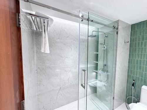 prysznic ze szklanymi drzwiami w łazience w obiekcie Wienglakor Hotel Lampang w mieście Lampang