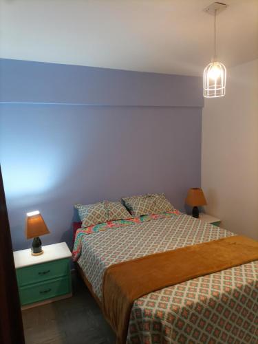 a bedroom with a bed and two lamps on a night stand at Departamento todo a mano parque central in La Cieneguita