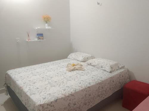 a bedroom with a white bed with a bow on it at Cantinho da Rosa in Santo Amaro