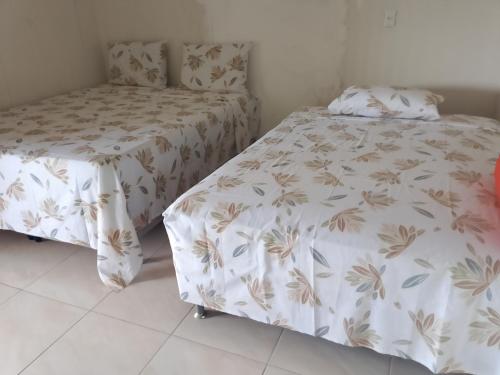 a bedroom with two beds and a bedskirts at Cantinho da Rosa in Santo Amaro