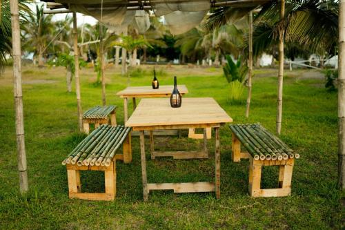 Una mesa de picnic y dos bancos en un parque. en Cabaña en la playa, en Monte Gordo