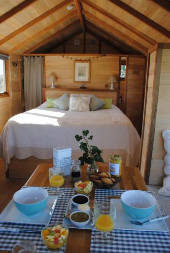 モンモリヨンにあるLa Cabaneのベッドルーム1室(ベッド1台、テーブル、食べ物付)
