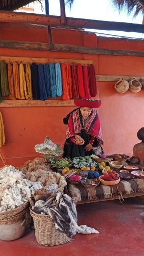 a woman sitting on a table in a market at Hotel Inka House Chinchero in Chincheros