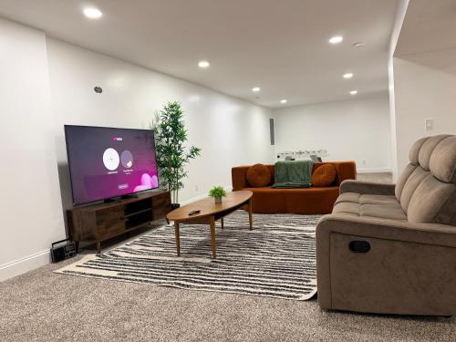 Una sala de estar con un sofá y un televisor en Relaxing Getaway, en Upper Marlboro