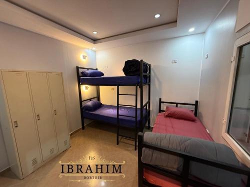een slaapkamer met twee stapelbedden in een kamer bij Dortoir Ibrahim in Tébessa