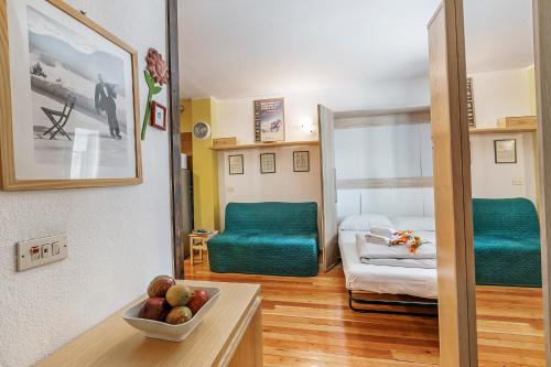 Grange SisesGrange Studio - Happy Rentals的一间房间里有一张绿色沙发，另一间房间里有一张床。