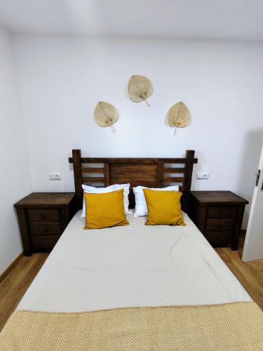 a bedroom with a large bed with yellow pillows at Casa do Retornado in Covas do Barroso