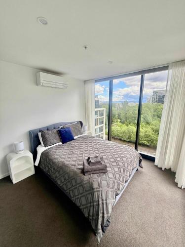 a bedroom with a bed and a large window at 2BR-2BR-2Cars -CBD-Pool-sleeps 6 in Canberra