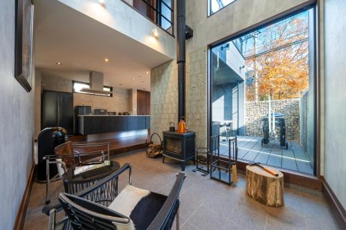 a living room with chairs and a fireplace and a large window at RIVER VIEW HOUSE-Sauna- in Nasushiobara