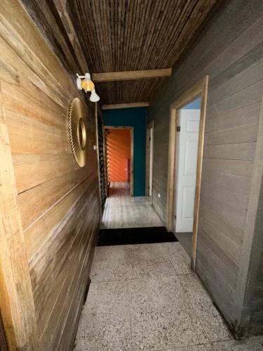 a hallway with a wooden wall and a door at Cahuitas red frog house in Talamanca