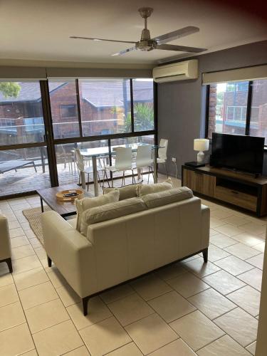 a living room with a couch and a television at The Gums Anchorage in Bellara