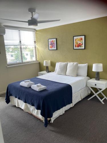 a bedroom with a large bed with a blue blanket at The Gums Anchorage in Bellara