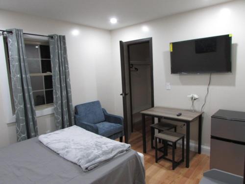 a bedroom with a bed and a desk and a television at Cozy Rooms in Ozone Park in Brooklyn Manor