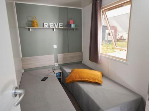 Saint-Martin-de-BremMobil-home 4 pers avec terrasse à Brem - API-1-52-438的窗户客房内的小床