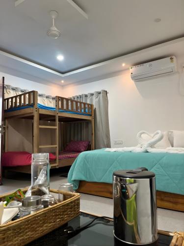 a room with bunk beds and a table with a blender at Teplong The Paix, Kaziranga National Park in Sakmuthi