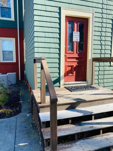 a wooden ramp in front of a house with a red door at Federal Hill Suites and Rooms in Providence