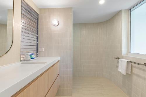 un bagno con lavandino e doccia di Serenity Apartments Noosa a Noosa Heads