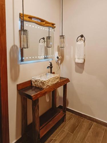 a bathroom with a wooden sink and a mirror at Hotel Cabañas Aldea Maya in Xpujil