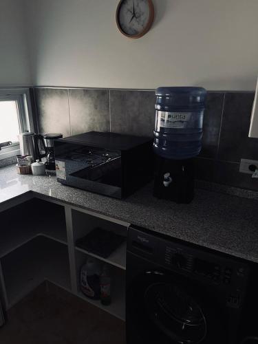 een keuken met een aanrecht met een klok aan de muur bij Antherina in San Luis