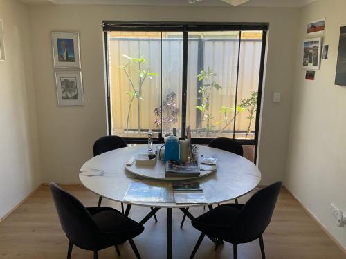 een tafel en stoelen in een kamer met een raam bij R and R Red Room in Perth