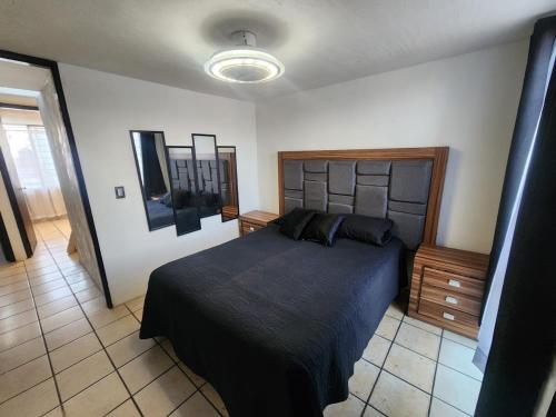 a bedroom with a large bed and a television at Casa entera, elegante, moderna in Guadalajara